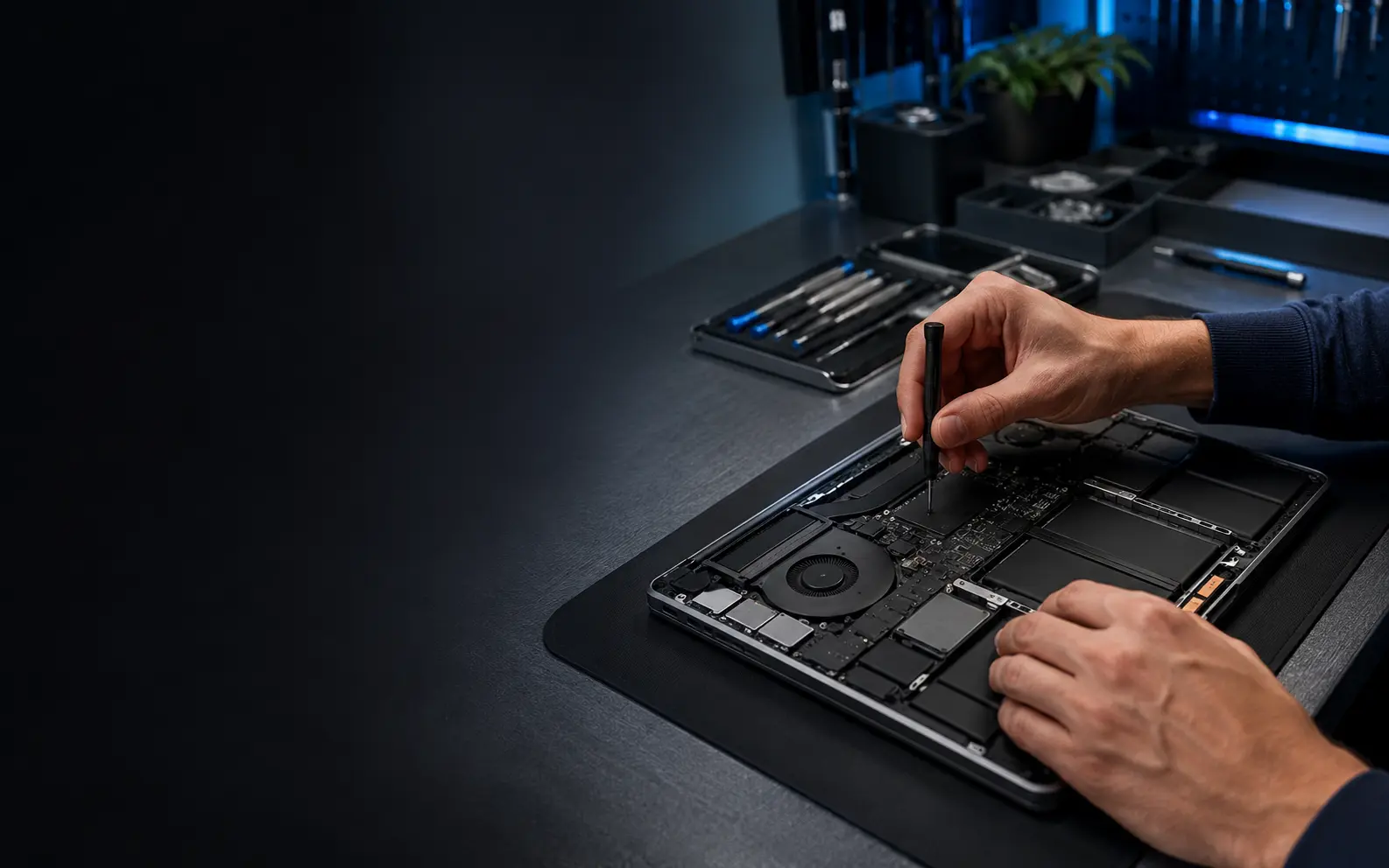 Technician diagnosing a laptop in a modern repair workshop